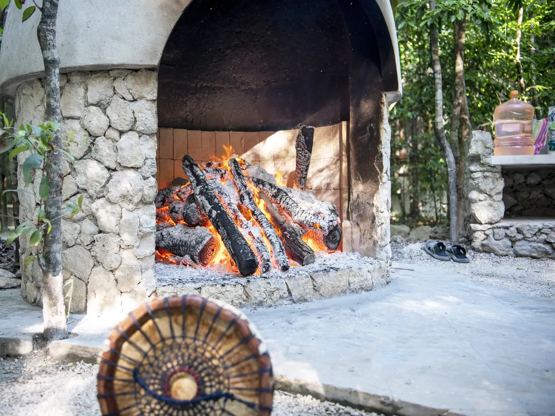 The temazcal fire burning beside the stone sweat lodge
