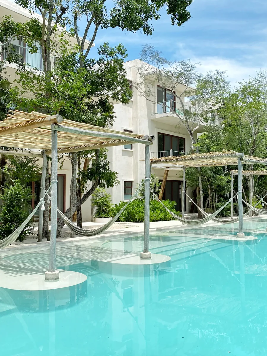 Holistika’s main pool, with hammocks under palm-thatch shades