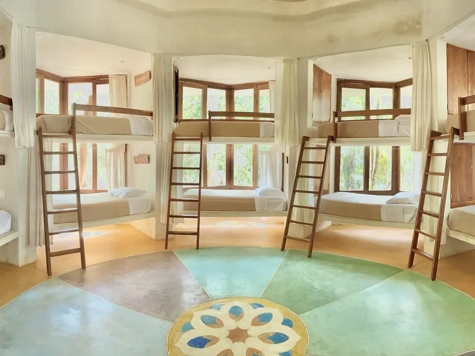 The Beehive at Holistika: eight bunks with ladders around a round, painted floor
