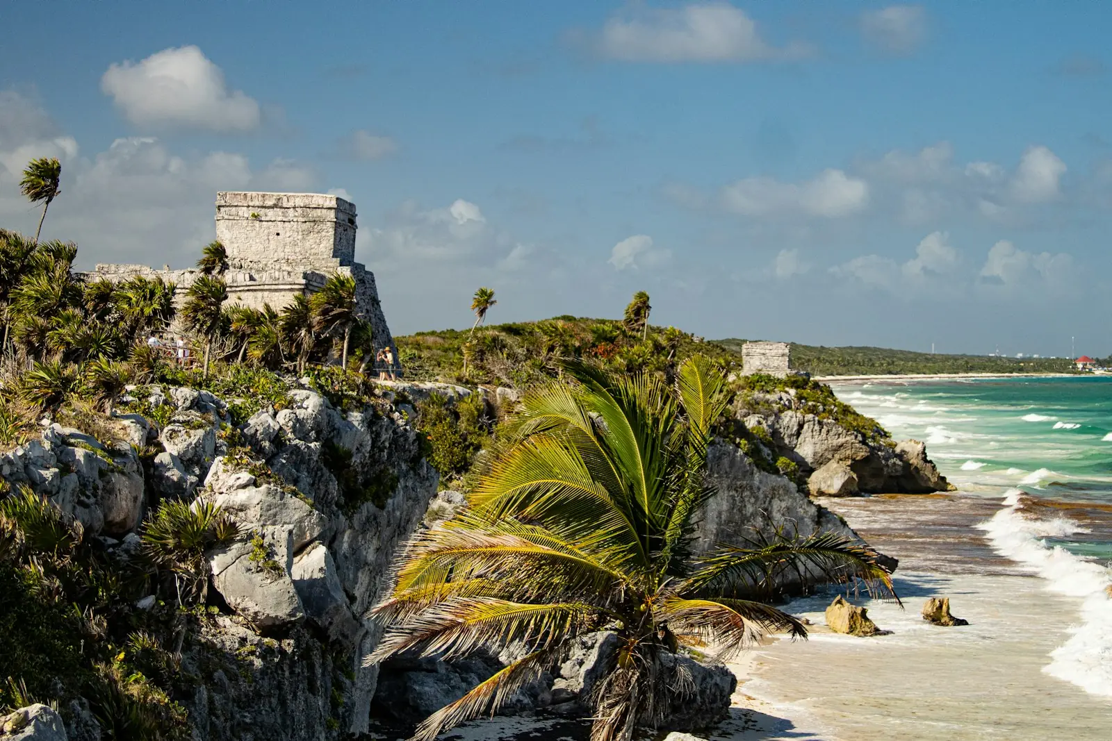 Ancient stone ruins on a cliff above turquoise Caribbean water